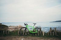 Free green bike leaning against wooden fence image, public domain landscape CC0 photo. 