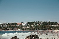 Free crowded urban beach, clear blue sky public domain CC0 photo.