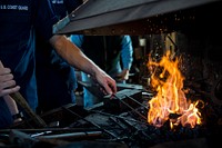 Blacksmitting metals fire with male hands. Original public domain image from Flickr