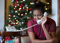 First Lady Michelle Obama reacts while talking on the phone to children across the country as part of the annual NORAD Tracks Santa program.