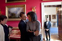 President Barack Obama hugs First Lady Michelle Obama in the Red Room of the White House while Senior Advisor Valerie Jarrett smiles prior to the National Newspaper Publishers Association (NNPA) reception, March 20, 2009.