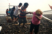 People pulling a fishing boat. Sisi yang Lain