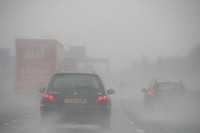 Cars driving on a busy road in fog. Original public domain image from Flickr