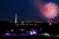With Brad Paisley onstage, a crowd watches from the South Lawn of the White House as fireworks erupt over the National Mall, July 4, 2012.
