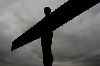 Angel statue with wings in the sky. It's large. Original public domain image from Flickr