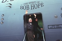 The Clintons wave from the doorway of The Spirit of Bob Hope airplane on departing from Sarajevo en route to Tuzla