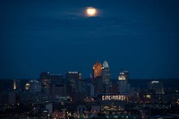 City at night with a full moon. Free public domain CC0 photo.