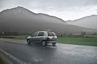 Blur View Of Car on road in the rain with mountain.