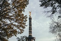 Free Berlin Victory Column through trees on a cloudy day photo, public domain monument CC0 image.