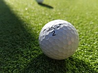 Closeup on golf ball in grass. Free public domain CC0 photo.