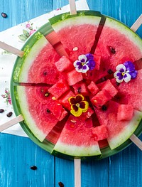 Overhead view of watermelon sticks on a plate on blue wooden surface, free public domain CC0 photo.