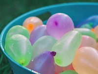 Close up of colorful water bombs in bucket. Free public domain CC0 photo.