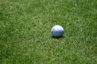 Close up of white golf ball on green grass. Free public domain CC0 photo.