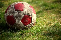 Closeup on old football in grass. Free public domain CC0 photo.