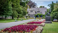 Cute house in garden, real estate. Free public domain CC0 photo.