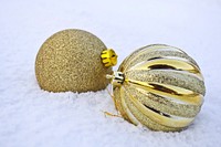 Closeup on golden Christmas ornaments on snow. Free public domain CC0 photo.