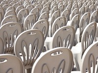 Many white plastic chairs in rows. Free public domain CC0 image.