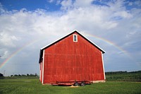 Rainbow over red barn house. Free public domain CC0 image.