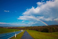 Rainbow over countryside roads. Free public domain CC0 image.