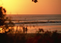 Silhouette of two girls on sunset beach, free public domain CC0 photo.