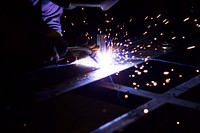 Welder working in factory, free public domain CC0 image.
