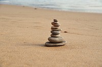 Free stacked rocks on sand image, public domain beach CC0 photo.