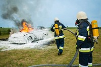 Free firefighters putting out fire from car photo, public domain CC0 image.