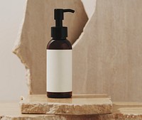 Brown dispenser bottle, blank white label, skincare product packaging, bathroom shelf