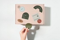Parcel box, hand attaching sticker, flat lay design