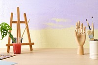 Aesthetic artist background, small easel and wooden hand mannequin, drawing class decoration