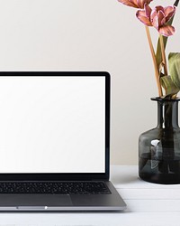 Aesthetic workspace with laptop and flower in vase