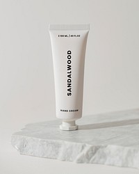 White hand cream tube, beauty product packaging, on marble product stand