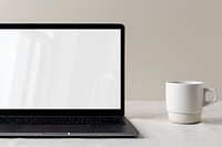 Empty computer laptop screen, modern home interior, cup of coffee