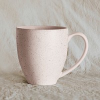 Pink handmade coffee mug on beige 