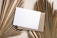 Aesthetic blank white invitation card and brown envelope, flat lay design