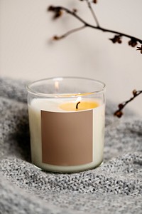 Home decor scented candle on gray blanket