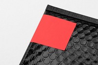 Black bubble mailer bag, red label, shipping packaging design