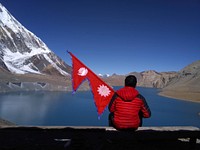 Man with Nepal national flag at Tilicho Lake, free public domain travel CC0 photo.