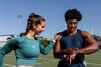 Male and female athletes looking at a fitness tracker data