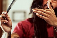 Barber trimming a customer's hair at a barber shop, small business