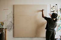 Woman artist painting on a big blank canvas