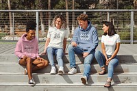 Diverse friends in casual apparel, talking on steps