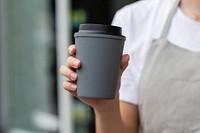 Barista holding gray takeaway coffee cup