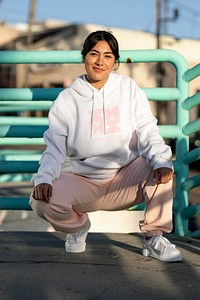 Woman wearing a streetwear hoodie, abstract pink and white design