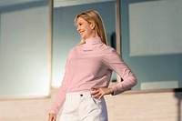 Blond woman wearing pink turtleneck outdoors