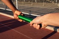 Team mate relaying the baton to another athlete 