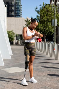 Woman with prosthetic leg looking at her smartwatch fitness tracker 