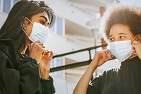 Two women wearing surgical masks in public