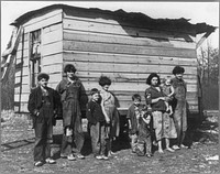 Family of nine living in open field in rough board covering built on old Ford truck chassis on U.S. Route 70, between Bruceton and Camden, Tennessee. Their water supply was an open creek running near highway. Sourced from the Library of Congress.