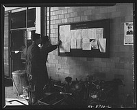 Wayne County Airport, a United States Army Air Corps air ferry command base sixteen miles from Detroit, Michigan. Mechanics repairing a mudguard on a wheel. Sourced from the Library of Congress.